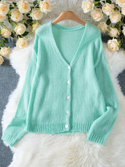 Light mint green mohair blend cardigan laid flat, showcasing its V-neck, button-down front, and ribbed details.