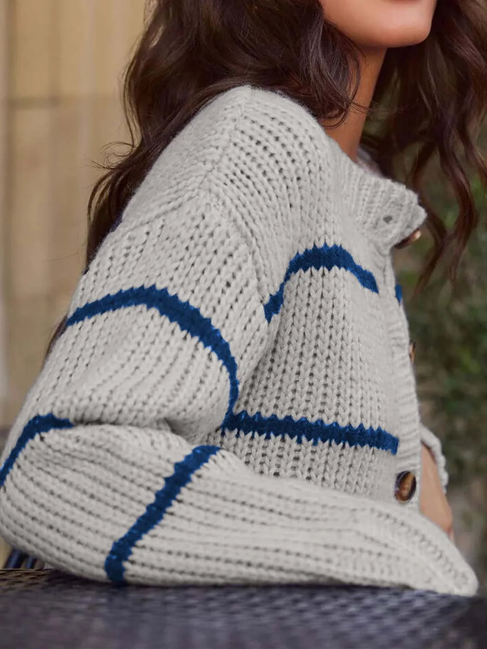 Close-up of the striped knit texture on a gray and blue cardigan.