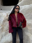 Woman wearing a burgundy faux fur cropped jacket with black leggings and sunglasses
