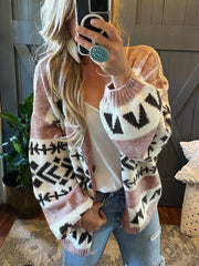 woman in a pink and black geometric print knit cardigan