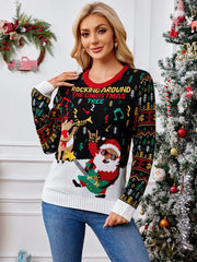 Woman wearing a black Christmas sweater with a graphic of Santa playing guitar and a reindeer, standing next to a decorated Christmas tree.