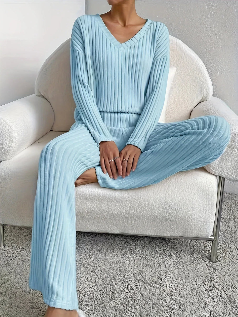 Woman sitting in a chair wearing a light blue ribbed loungewear set