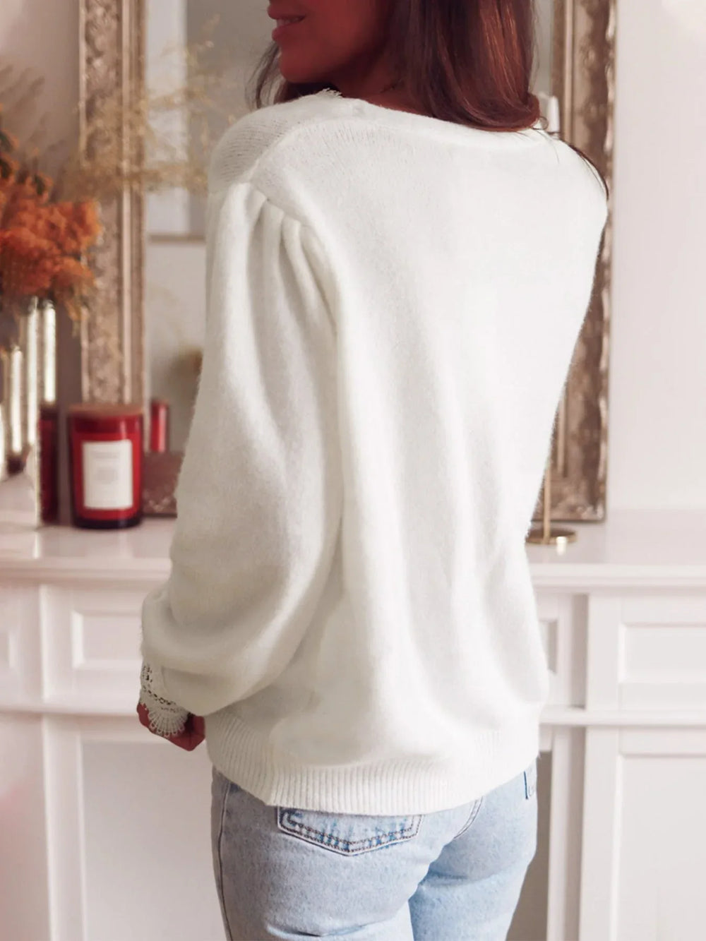 Back view of a woman wearing a white knit cardigan