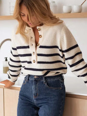Woman in a striped knit sweater and blue jeans, looking down