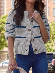 Front view of a woman in a gray and blue striped knit button-up cardigan.
