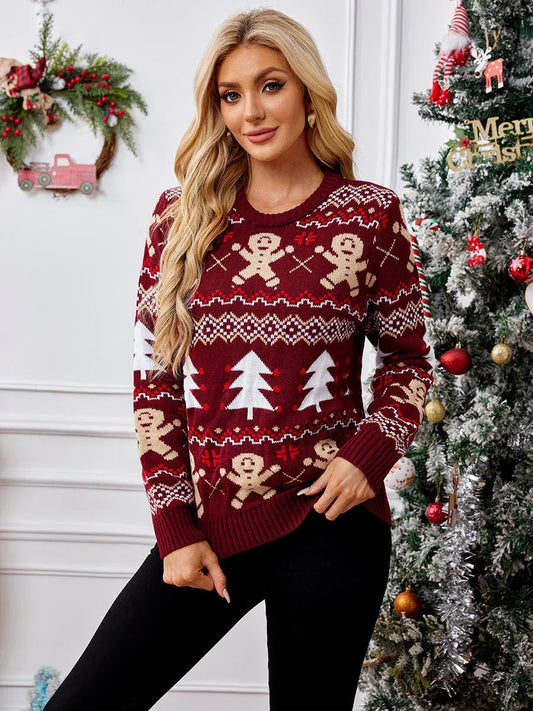 Woman wearing a red Christmas sweater with gingerbread man and Christmas tree patterns, standing in front of a Christmas tree.