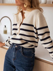 Woman wearing a striped knit sweater and blue jeans, leaning on a counter