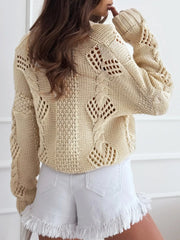 Back view of a cream-colored, open-knit, cropped cardigan with a V-neck and button-up front.