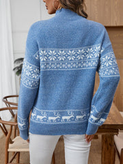 Back view of a woman wearing a blue knit sweater with a white Fair Isle snowflake and reindeer pattern.