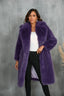 Woman wearing a long purple faux fur coat with a white top and black pants
