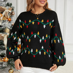 Front view of a woman wearing a black knitted sweater with a Christmas lights pattern
