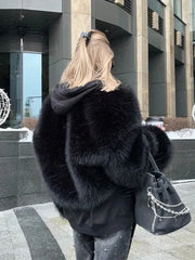 Back view of a woman wearing a black faux fur jacket and studded jeans, carrying a handbag