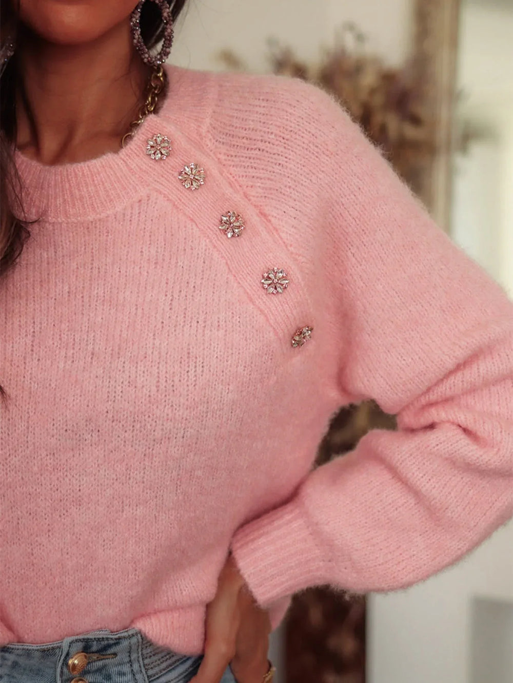 Close-up of the embellished button detail on a pink mohair blend sweater.