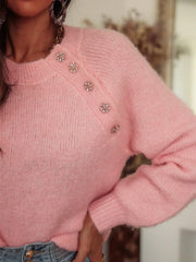 Close-up of the embellished button detail on a pink mohair blend sweater.
