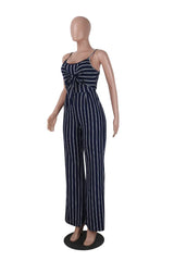 Mannequin wearing a navy and white striped jumpsuit with a tie-front detail and wide legs, side view.