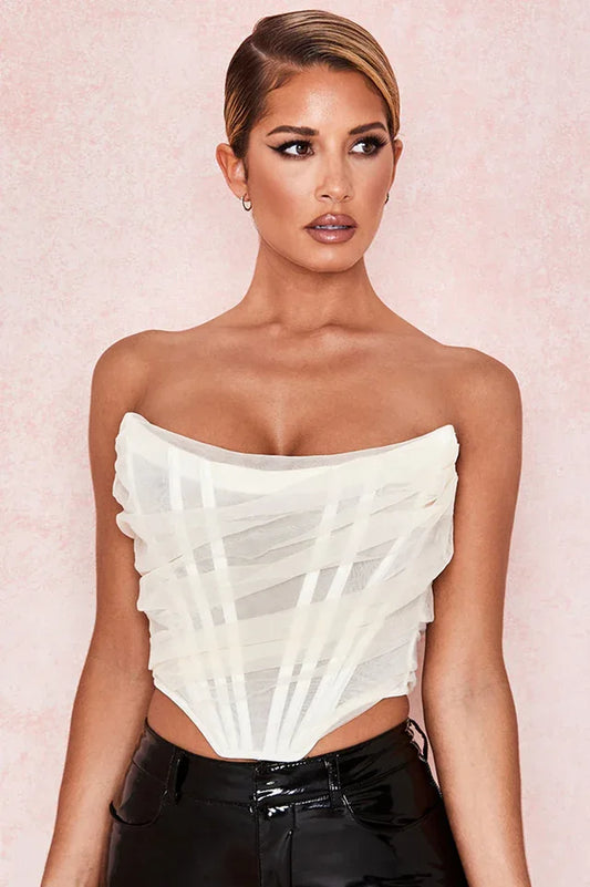 woman wearing a white strapless corset top with black pants