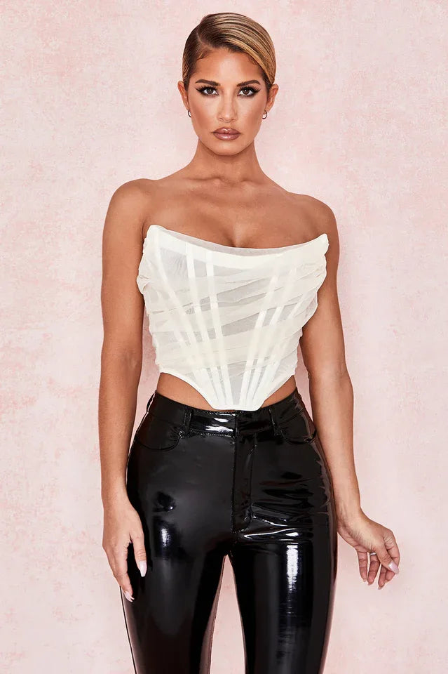 woman wearing a white strapless corset top and black pants, close-up