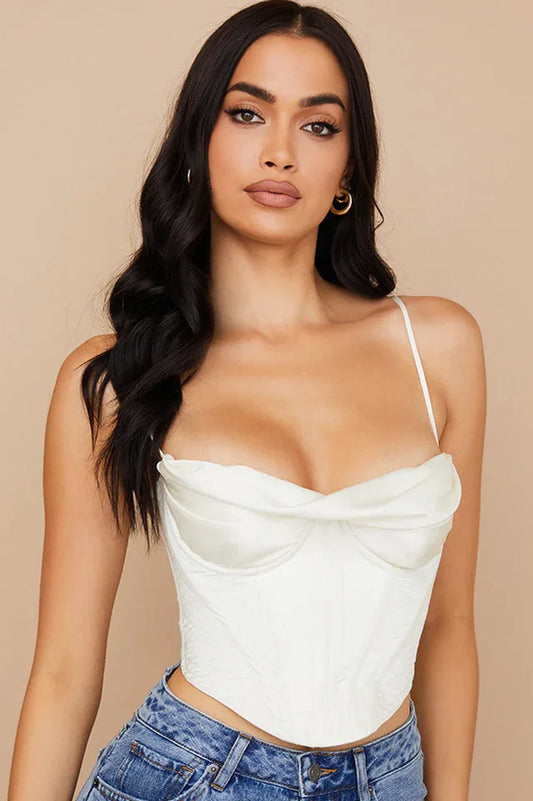 Woman wearing a white satin corset top and blue jeans