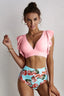 Woman wearing a pink v-neck bikini top with flutter sleeves and floral high-waisted bottoms