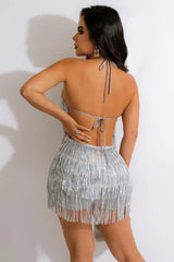 Woman in a silver sequined fringe mini dress, back view