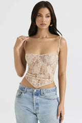 Front view of a woman in a beige lace corset top with a scarf hem and spaghetti straps.