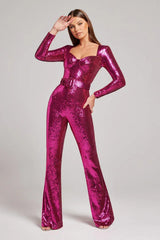 Woman in a vibrant pink sequined jumpsuit with a sweetheart neckline and flared legs, striking a pose.