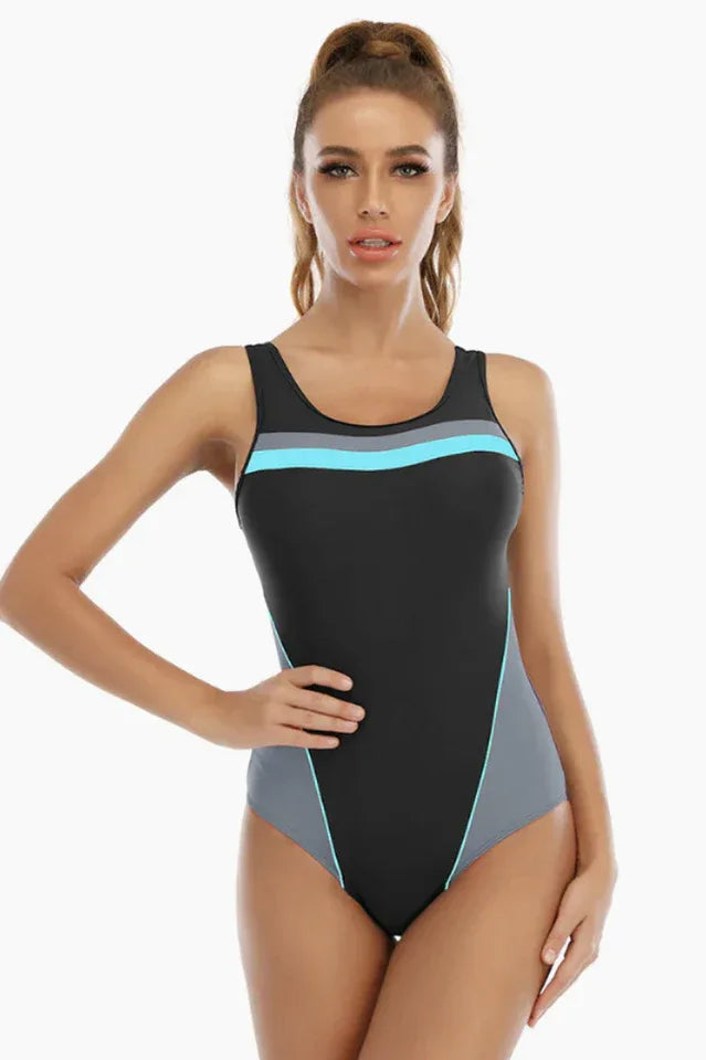 Woman wearing a black one-piece swimsuit with grey and blue accents