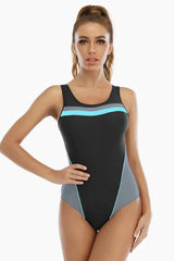 Woman wearing a black one-piece swimsuit with grey and blue accents