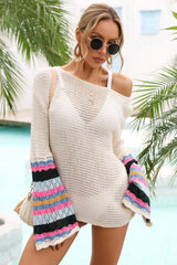 Woman wearing a white crochet mini dress with colorful striped bell sleeves and a V-neckline, standing by a pool.