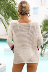 Back view of a woman in a white crochet mini dress with colorful striped bell sleeves.