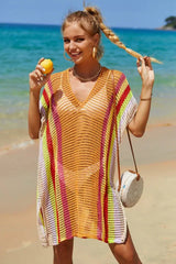 Woman wearing a colorful striped knit beach cover-up and holding a lemon on the beach.