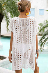 Back view of a woman in a white crochet knit beach cover-up.