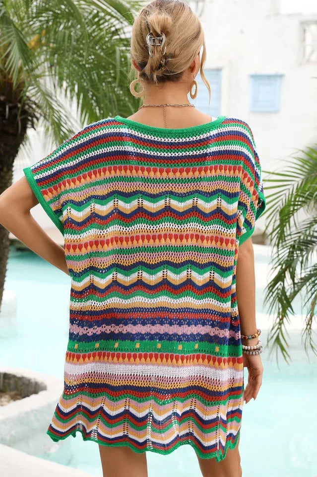 Back view of a woman wearing a colorful striped crochet knit tunic with a v-neck and short sleeves.
