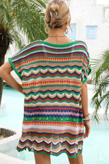 Back view of a woman wearing a colorful striped crochet knit tunic with a v-neck and short sleeves.