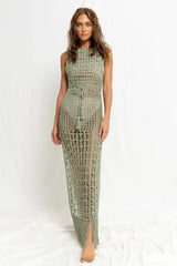 Woman wearing a green crochet knit maxi dress with a tie waist, front view.