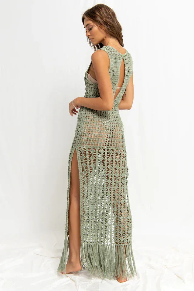 Woman wearing a green crochet knit maxi dress with an open back detail, side back view.