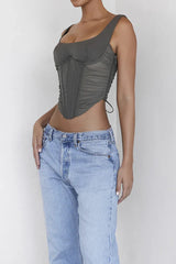 Close-up of a woman's torso in a khaki ruched corset top with a square neckline.