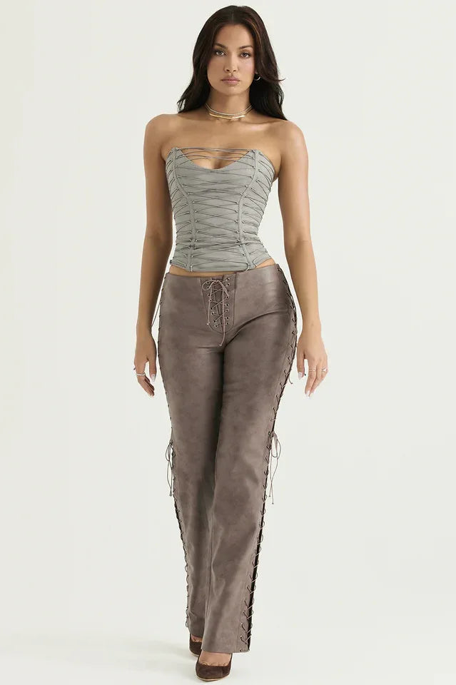 Full body shot of a model in a gray strapless lace-up corset top and brown faux leather lace-up pants