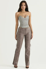 Model posing in a gray strapless lace-up corset top and brown faux leather lace-up pants