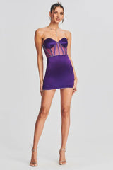Full-length view of a model in a purple satin strapless mini dress with sheer panel detailing.