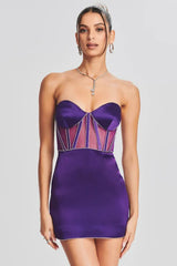 Model wearing a strapless purple satin mini dress with sheer corset-inspired panels and crystal embellishments.