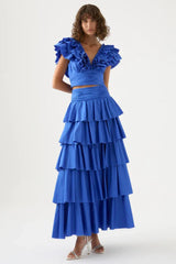 Woman wearing a blue ruffled crop top and a tiered blue maxi skirt