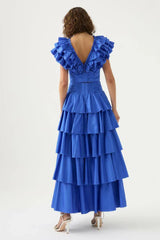 Back view of a woman in a blue ruffled crop top and tiered blue maxi skirt