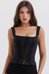 Woman wearing a black corset top with a sweetheart neckline and tie detail