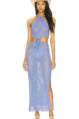 Woman wearing a blue crochet knit maxi dress with a halter neck and cut-out details, with a straw hat.