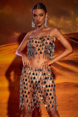 Woman wearing a silver sequin crop top and mini skirt set with fringe detailing