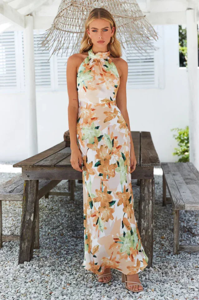 woman wearing a floral print maxi dress with a halter neckline