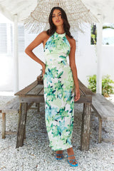 woman standing by a table in a floral print maxi dress