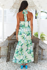 back view of a woman in a floral print maxi dress with a tie-back detail