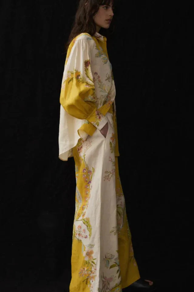 Side view of a woman modeling a paneled floral print linen outfit.